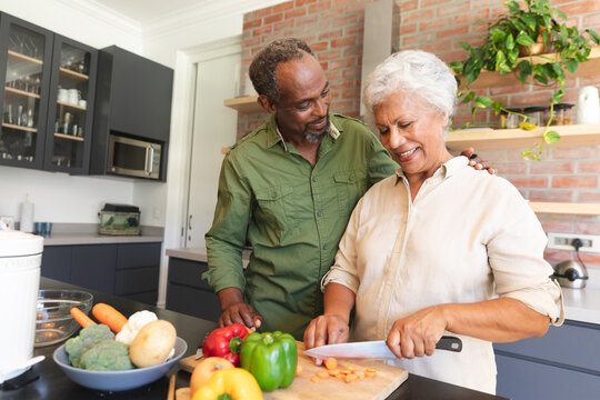 Senior African American couple cooking in kitchen