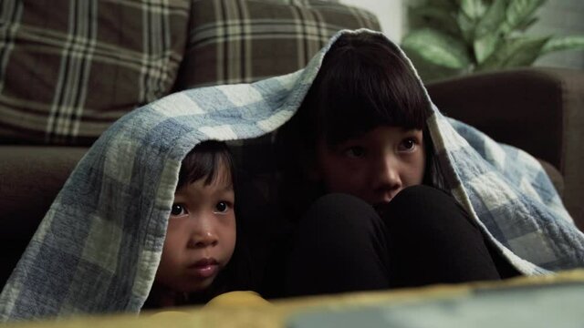 young little girls, Thai kids looking horror movie, scared and shocked feeling