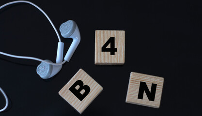 B4N - acronym on wooden cubes on a black background with headphones