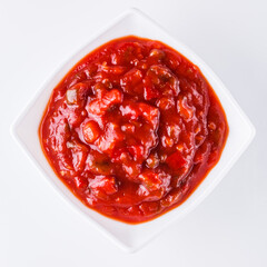 Fresh tasty tomato sauce on a white background
