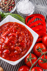 Fresh tasty tomato sauce on rustic wooden background