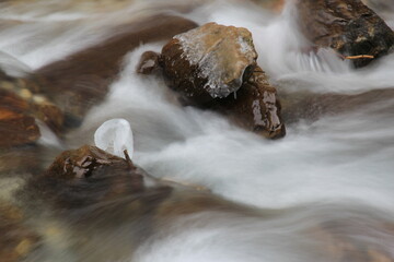 Milky like water and rocks in winter cold river.