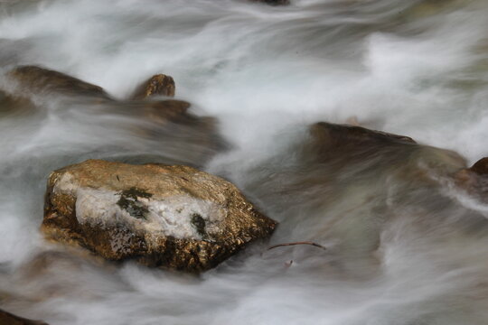 Stream, rocks and water in autumn forest.