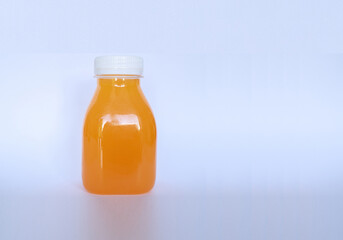 Small orange juice bottle for adding logo or branding  isolated on abstract white background.  Copy space. Close up and selective focus.
