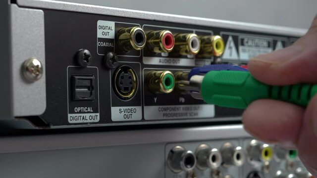 Male Hands Connecting Cables To A DVD Player. Close-Up. Component Video Cables Plug-In To Multimedia Electronic Device At Home..