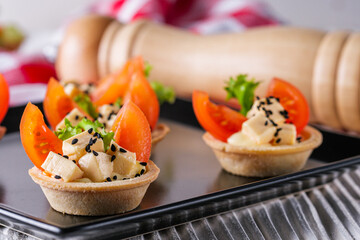 delicious snack tartlets on rustic wooden background
