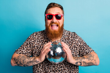Photo of cool macho guy holding glitter mirror disco ball chill rest party excited good mood tattoo...