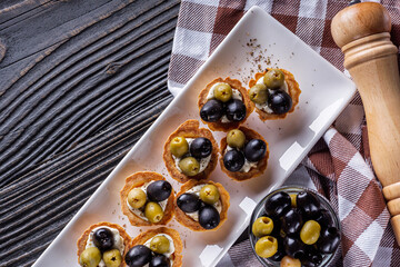 delicious snack tartlets on rustic wooden background