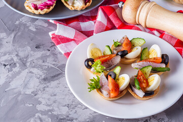 delicious snack tartlets on dark stone background
