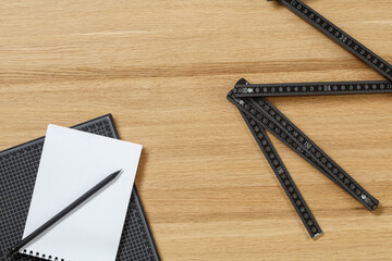 Spiral notebook and various rulers on wooden table. Set of measuring equipment and stationery....