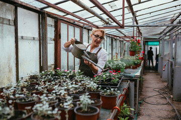 women working in greenhouse flowers nursery. small business concept