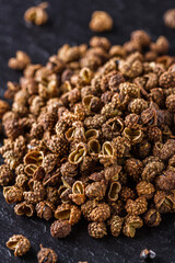 Sichuan pepper on a dark stone background