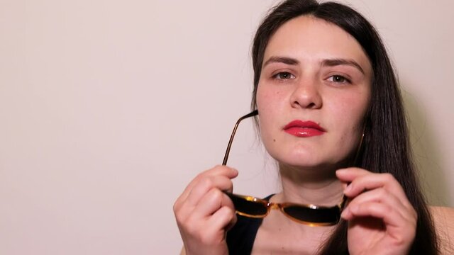 The girl squints, does not see well. She wears glasses training equipment to improve vision. Perforated glasses with holes.