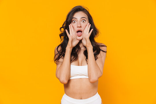 Image of excited woman in white swimsuit posing and screaming at camera