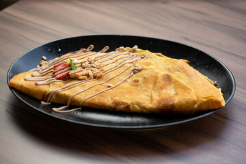 Delicious crepes with fresh strawberries,milk chocolate and biscuit