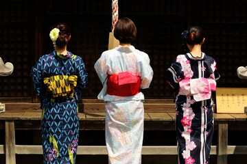 日本の神社でお参りする美しい浴衣の女性