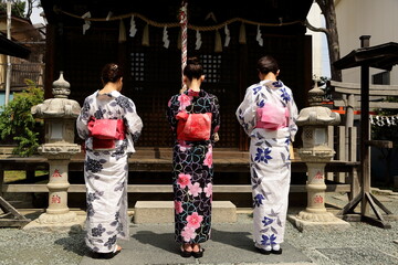日本の神社でお参りする美しい浴衣の女性