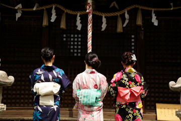 日本の神社でお参りする美しい浴衣の女性
