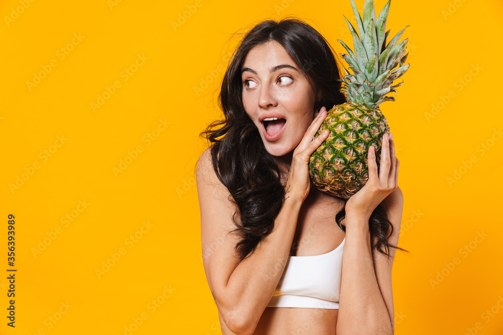 Sticker image of excited brunette woman holding pineapple and looking aside