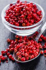pink peppercorns on a dark stone background