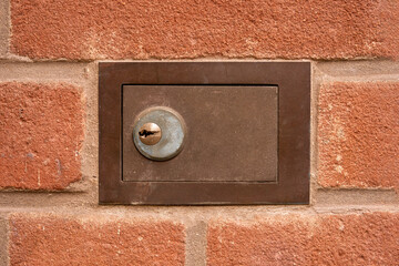 Kleiner Wandtresor in einer roten Außenwand aus Klinkersteinen