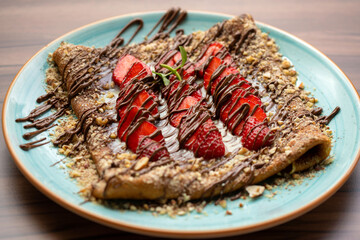 Sweet crepes with strawberries and chocolate sauce
