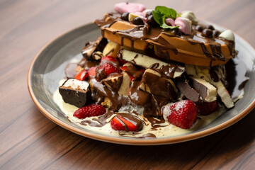 Delicious waffles with fresh fruits, ice cream, strawberry, colorful candy, different toppings - sweet food