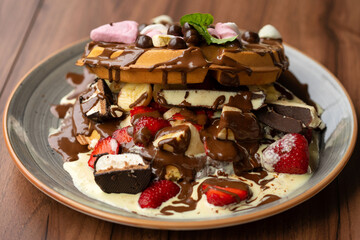 Delicious waffles with fresh fruits, ice cream, strawberry, colorful candy, different toppings - sweet food