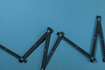 Graph-shaped measuring ruler. Growth in the form of a growing chart. Concept of falling and growing sales, statistics data and construction costs