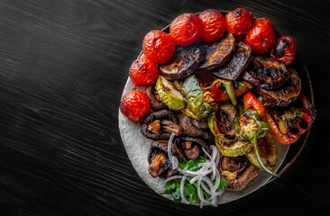 Assorted Grilled vegetables in plate on black wooden table background