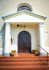 White entrance to the church with two pillars.