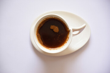 White cup with hot black coffee on the white background