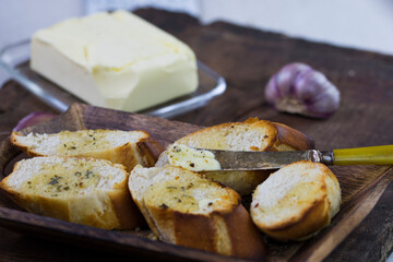 Garlic bread served on a wooden tray.