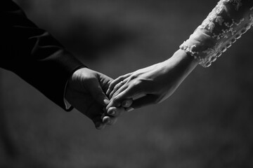 Black and white wedding photography of wedding couple, bride and groom holding hands, beautiful wedding day