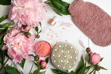 Obraz na płótnie Canvas Natural organic cosmetic products with pink peonies flowers on white background. Spa relax Treatments and anti-cellulite massage