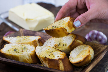 Garlic bread served on a wooden tray.