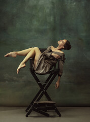 Beautiful portrait, dreamful. Graceful classic ballerina dancing, posing isolated on dark studio...