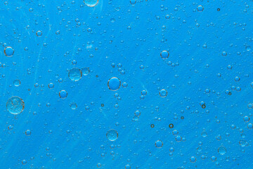 Abstract blue background with oil drops and waves on water surface