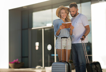 Fototapeta na wymiar Travel concept. Couple checking tickets near airport