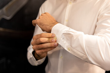 Man. People, business,fashion and clothing concept - close up of man dressing up and adjusting white shirt with cufflinks