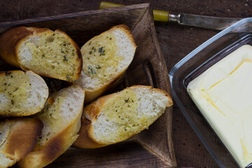 Garlic bread served on a wooden tray..