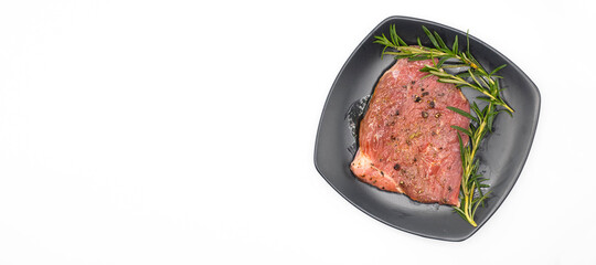 Raw beef with rosemary in black dish on white background, copyspace for you design, Top view.