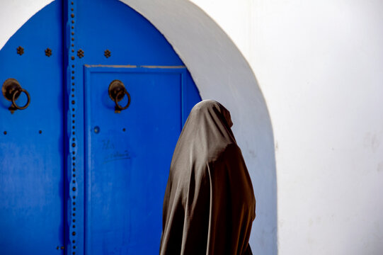 Tunisia. Sidi Bou Said. Woman in chador walking in the Medina