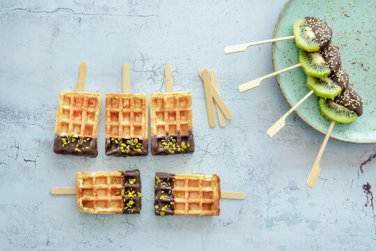 Kiwi am Stiel und Waffeln mit Kardamom-Schokolade, Pistazien und Sesam
