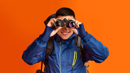 Portrait of smiling hicker using modern binoculars