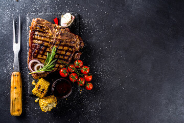 Cooking meat background. Homemade fresh grilled meat. Grilled  t-bone steak medium rare on dark...