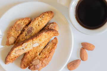 Fresh baked Italian cantucci with almonds with a cup of coffee. Tuscan Biscotti. Traditional cantuccini. Homemade Italian sweets biscuits (cookies). Italian morning. Selective focus.