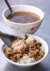 Braised meat rice, stewed beef over cooked rice in Tainan, Taiwan. Taiwanese famous traditional street food delicacy. Travel design concept, closeup.