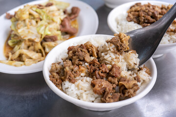 Braised meat rice, stewed beef over cooked rice in Tainan, Taiwan. Taiwanese famous traditional street food delicacy. Travel design concept, closeup.