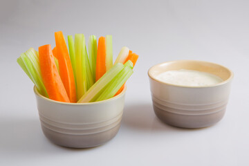 close up isolated shot of a mixed bowl of crunchy orange carrot slices and juicy green celery...